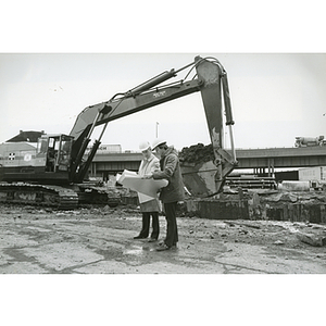 Co-op student and supervisor review plans on construction site