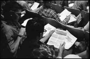 Students looking over the Selective Service College Qualification examination to determine eligibility for an educational deferment from service in the Vietnam War