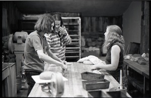 Sammy Wolf, Nick Carson, and Julie Howard (l. to r.) working in commune bakery