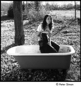 Jenny Rose seated in a tub outdoors with dog, Tree Frog Farm Commune