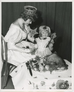 Susan Rainer feeding turkey to Susie Renken