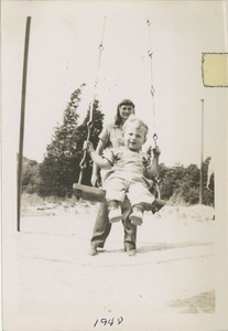 Unidentified woman and child on swing at Houghton's Pond