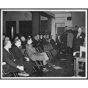 Audience seated, watching a presentation