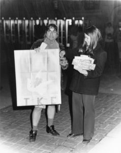A member of Suffolk University's Tau Kappa Epsilon chapter dressed in drag while fundraising for UNICEF, talks to a woman with McGovern/Shriver '72 stickers