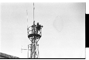 RUC station Downpatrick. Police engineer servicing the electronic mast in the grounds. Candid shot using long lens