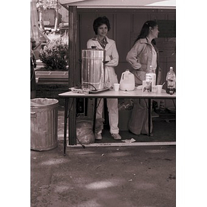 Two women work at a food vending stand at a Latino street festival