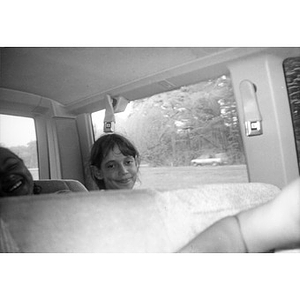 Two girls inside a van or school bus en route to their field trip destination.