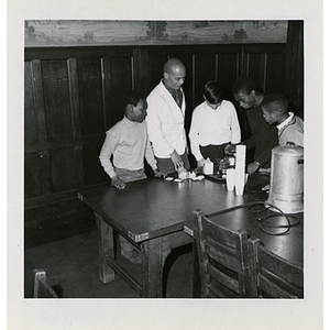 A man and four boys prepare drinks during a Race Committee meeting