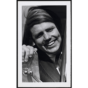 A male staff member smiling from a car