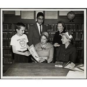 "George Albrecht, 11, and Philip Ash, 12, receiving library awards at Roxbury Clubhouse during Boys' Club week for outstanding book awards from Mrs. Margaret Widdemer, former winner of Pulitzer Prize for poetry, Mrs. Marjorie Matthews, Librarian, and Mrs. Barbara Sherman Burger of the Boys' Clubs Library Advisory Committee"