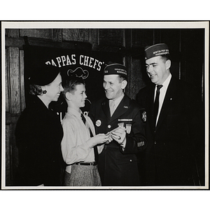 Two men, wearing side caps, present an award to a Boys' Club member while Barbara Sherman Burger, at far left, looks on