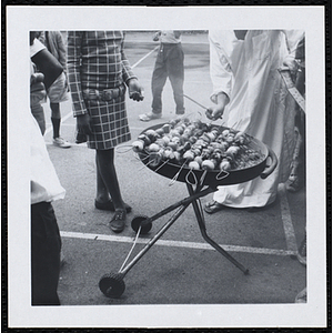 A man grills sheesh kababs at a picnic