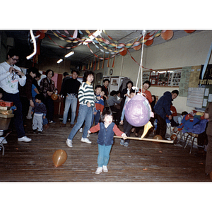 Guest swings at a piñata during the Chinese Progressive Association's children's party