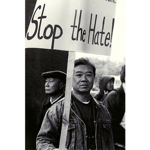 Chinese man holding a sign that reads, "Stop the Hate!" at a rally for immigrant rights and welfare reform