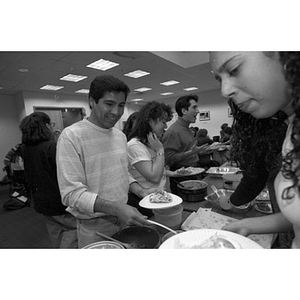 A student puts food on his plate at a Law School luncheon sale