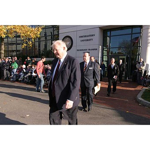 Several men walk out of Egan Research Center for the Veterans Memorial dedication ceremony