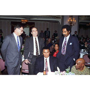 Muhammad Ali sits at a table at the Center for the Study of Sport in Society's annual banquet