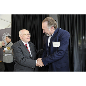 Dr. George J. Kostas shakes hands with Robert Mercier at the groundbreaking ceremony for the George J. Kostas Research Institute for Homeland Security, located on the Burlington campus of Northeastern University