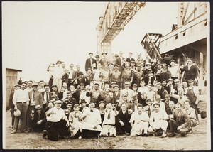 Workers pose for a picture underneath the railroad bridge