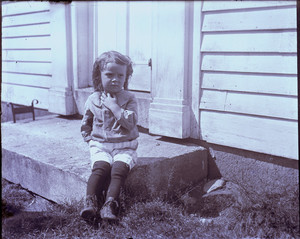 Child sitting on a doorstep, East Douglas, Mass.
