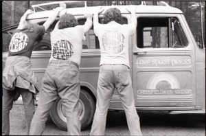 Three members of the Brotherhood of the Spirit Community feigning arrest, wearing Spirit in Flesh t-shirts and leaning against the Free Spirit Press van