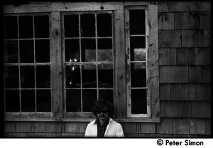 Laurie Dodge standing outside a house window, Packer Corners commune