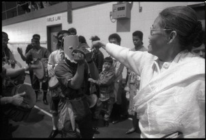 Cambodian New Year's celebration: woman placing money between a musician's cymbals