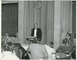 Ellsworth Barnard standing indoors, behind podium, addressing group