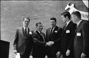 Governor Volpe and Elliot Richardson at Boston University: Richardson on stage with Volpe, who greets three other men