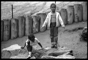Children playing on large rocks in a playground