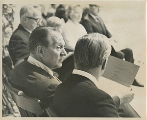 Art Linkletter seated looking at program