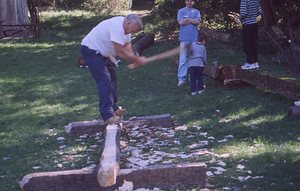 Hopkins Forest Fall Festival, 1999. 4. Kris Kirby (blue tee-shirt) looks on as Richard Babcock shapes a beam.