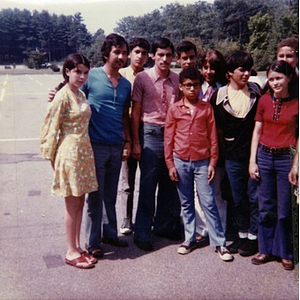 Seven male and three female Hispanic American youths pose for a group photograph in the parking lot adjacent to a park