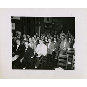 Committee members, seated in chairs, look at the camera during a Boys' Club meeting