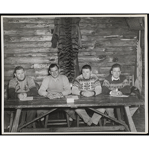 Four young men seated at a table in the South Boston Clubhouse