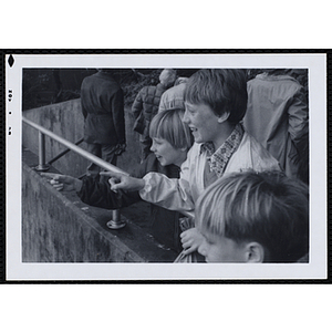 Three boys enjoy an exhibit at a zoo