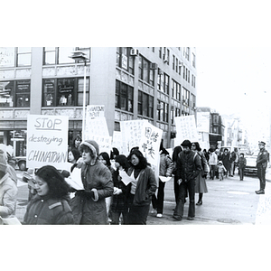 Chinese Progressive Association helps the community organize and oppose the New England Medical Center's Nutrition Center by marching through Chinatown carrying protest signs and handing out information