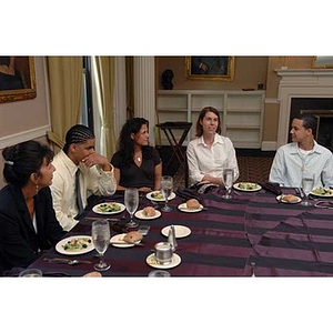 Four people listen to Meghan Eliason at the Torch Scholars Manganaro Luncheon