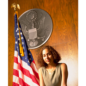 Criminal justice co-op student standing in front of United States flag and seal