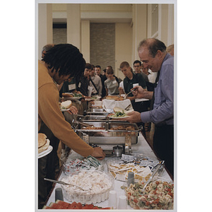 Attendees of the School of Law orientation filling plates at the buffet table, 1998