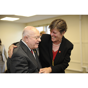A woman embrace Dr. George J. Kostas at the groundbreaking for the George J. Kostas Research Institute for Homeland Security