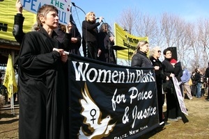 Protesters holding up a banner reading 'Women in Black for Peace and Justice': rally and march against the Iraq War