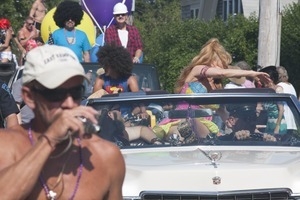 Grand Marshall Charo riding in the parade, waving to the crowd : Provincetown Carnival parade