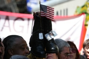 Marcher holding up combat boots and dogtags during the march opposing the war in Iraq