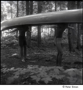 Camp Arcadia: campers carrying a canoe through the woods