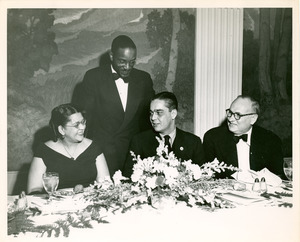 Yolande Du Bois and unidentified persons at dinner