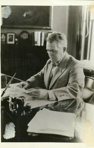 Hugh P. Baker reading at his office desk