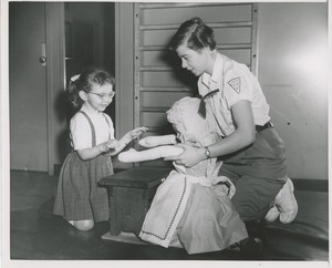 Physical therapist with young girl and doll