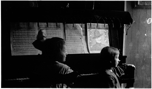 Two girls at a piano in the Back Central Street neighborhood. [02]