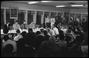 Ringo Starr, Paul McCartney, John Lennon, and George Harrison (l. to r.) seated at a table during a Beatles press conference